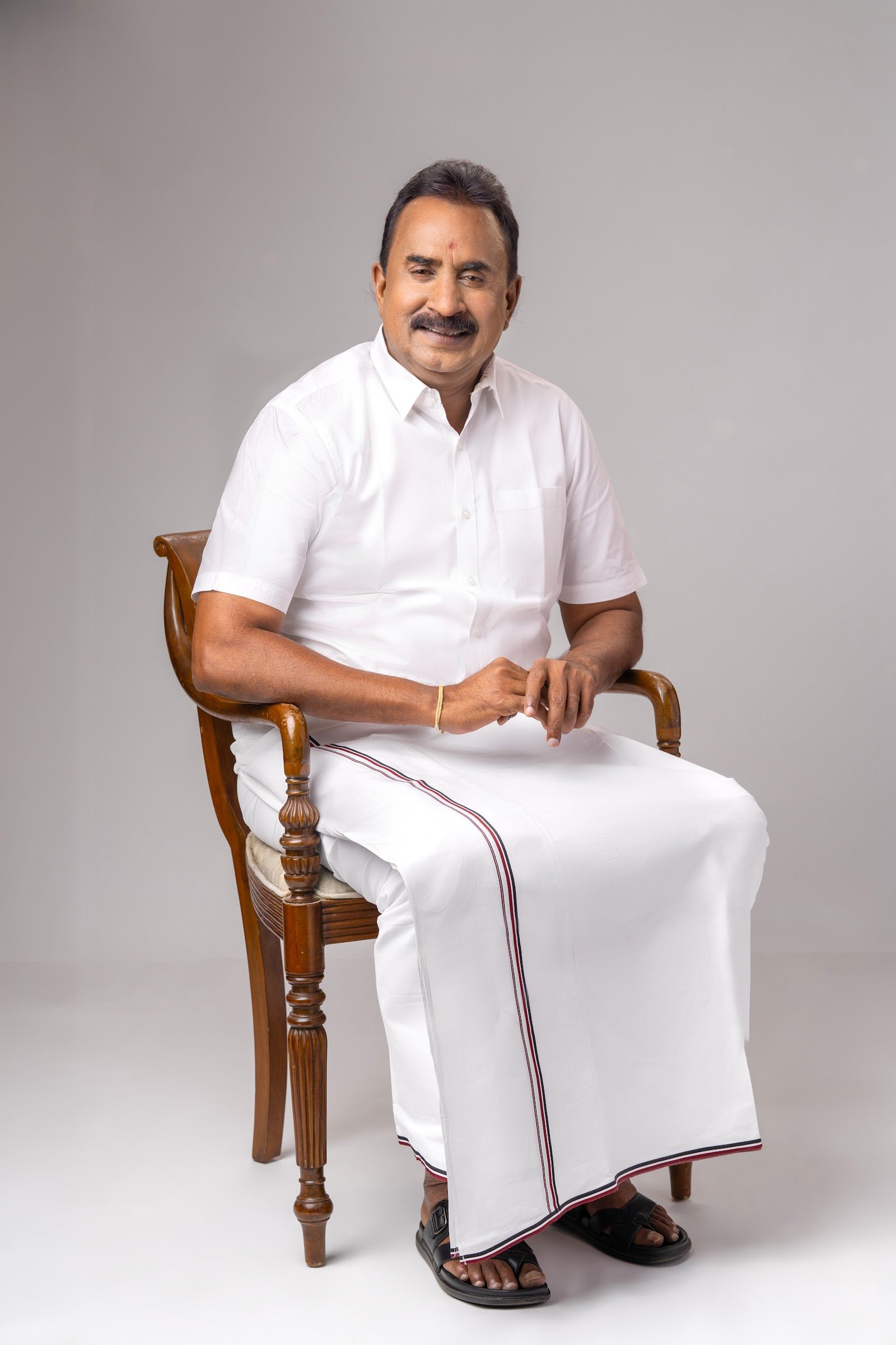 S. P. Velumani smiling in a seated portrait