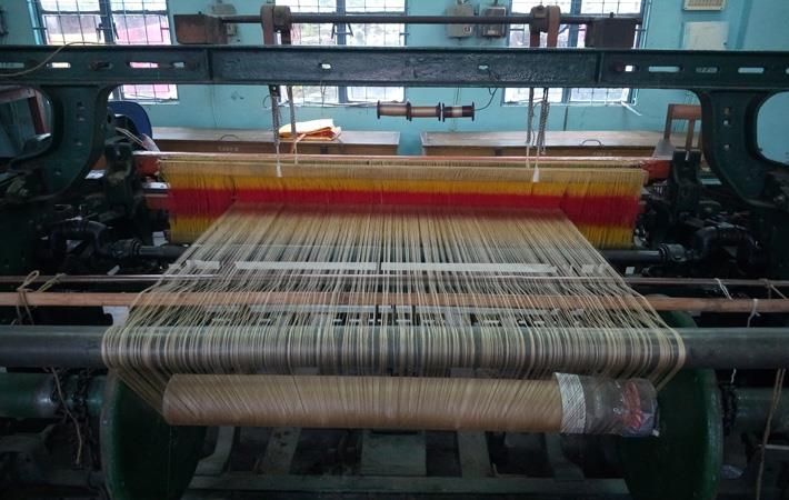 A power loom weaving coloured fabric