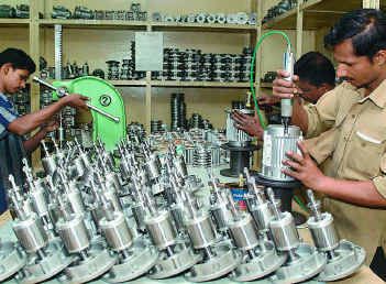 Workers assembling machine parts in a small workshop